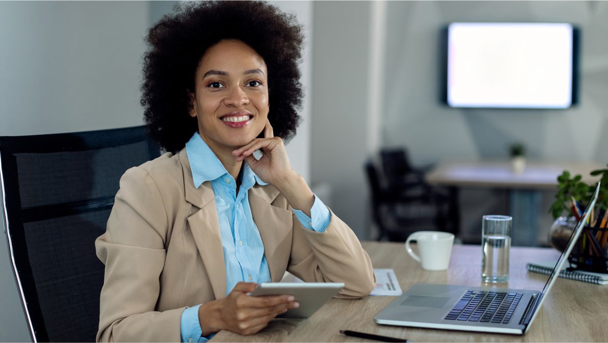 image of a smiling woman sitting on her work desk